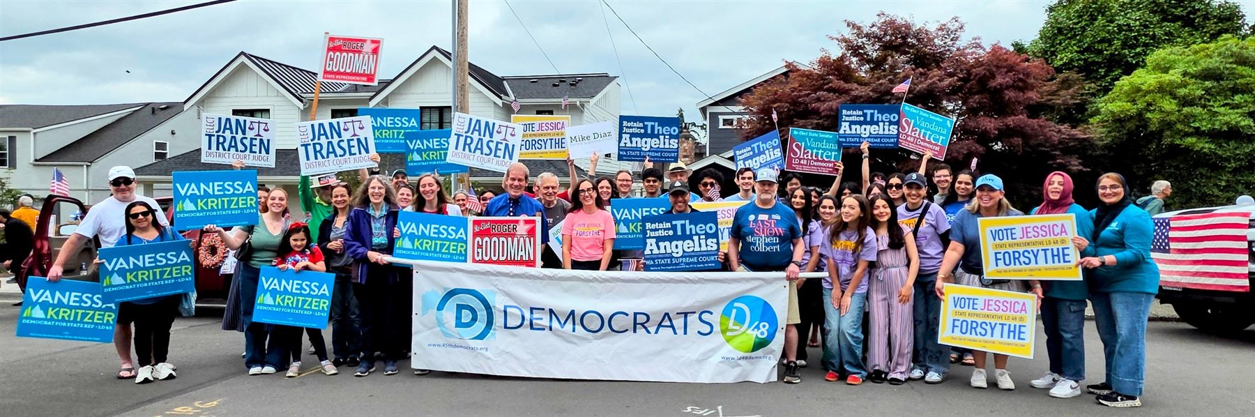 LD 48 Democrats and community members gather with campaign signs before a July 4 parade in 2026.